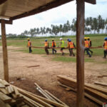 Team carrying roof trusses