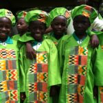ghanaian child stood at chalkboar
