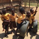 image: children playing with tyres